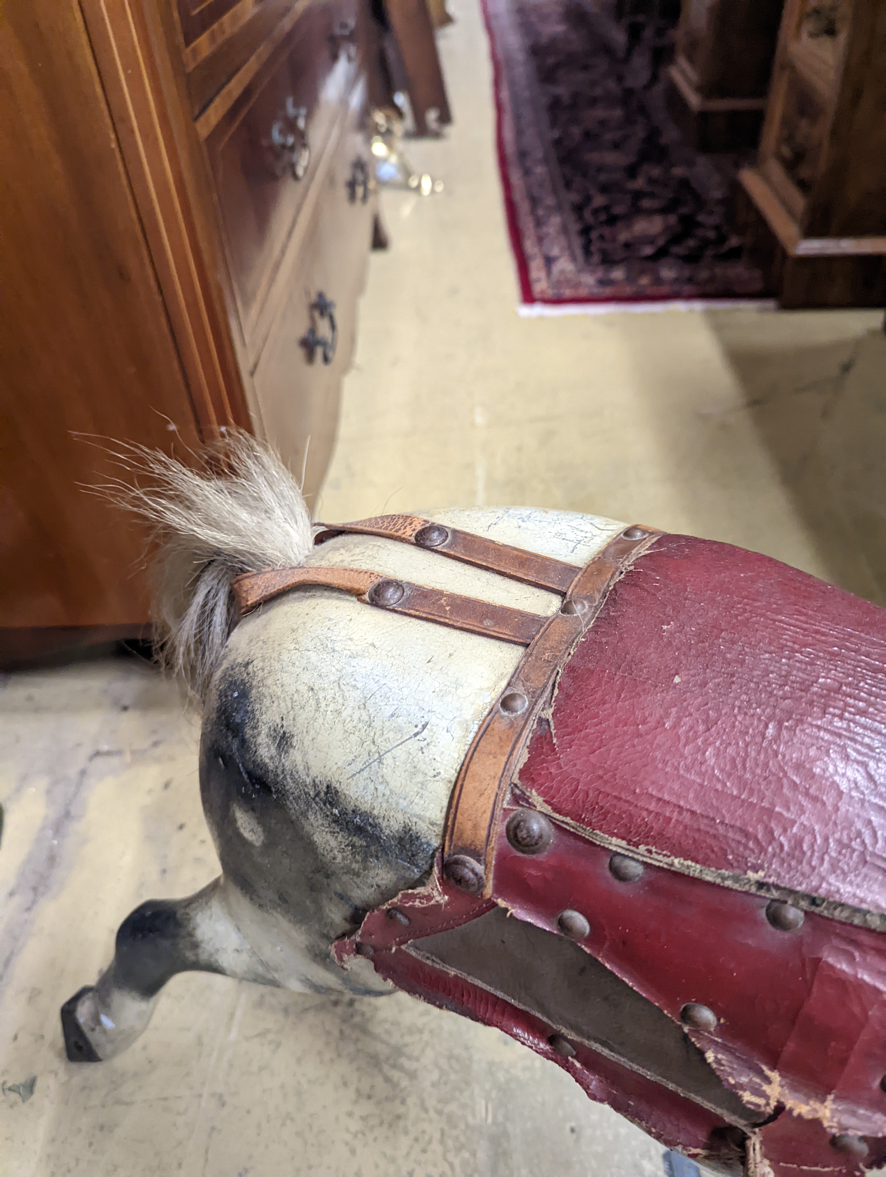 A Victorian carved and painted wood rocking horse, lacking underframe, length 77cm and two painted wood hobby horses, 58cm and 38cm